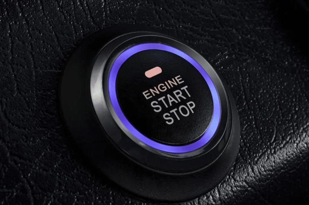 Blue-lit engine start-stop button on leather dashboard